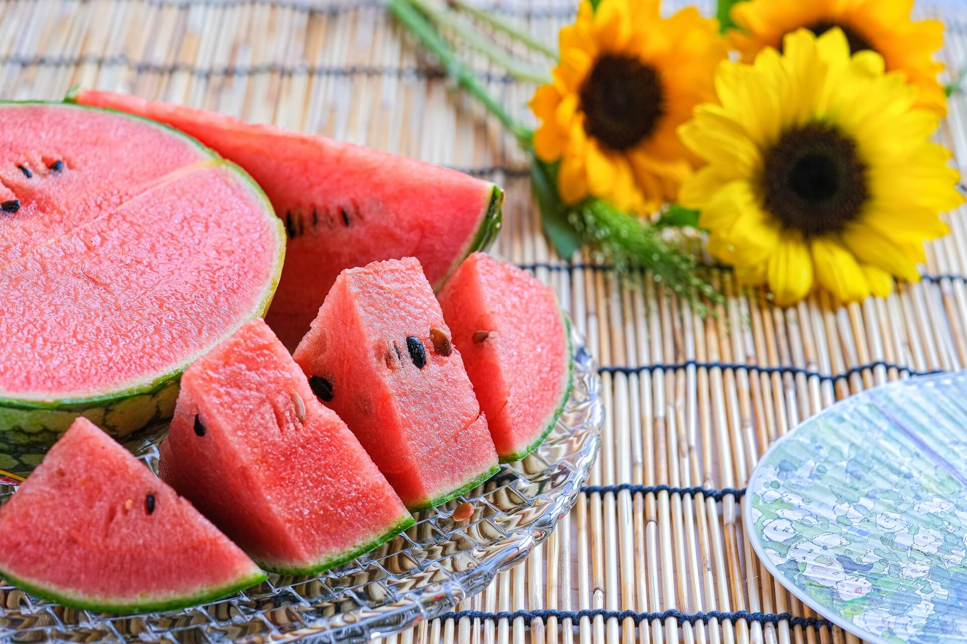 カットされたスイカとひまわり