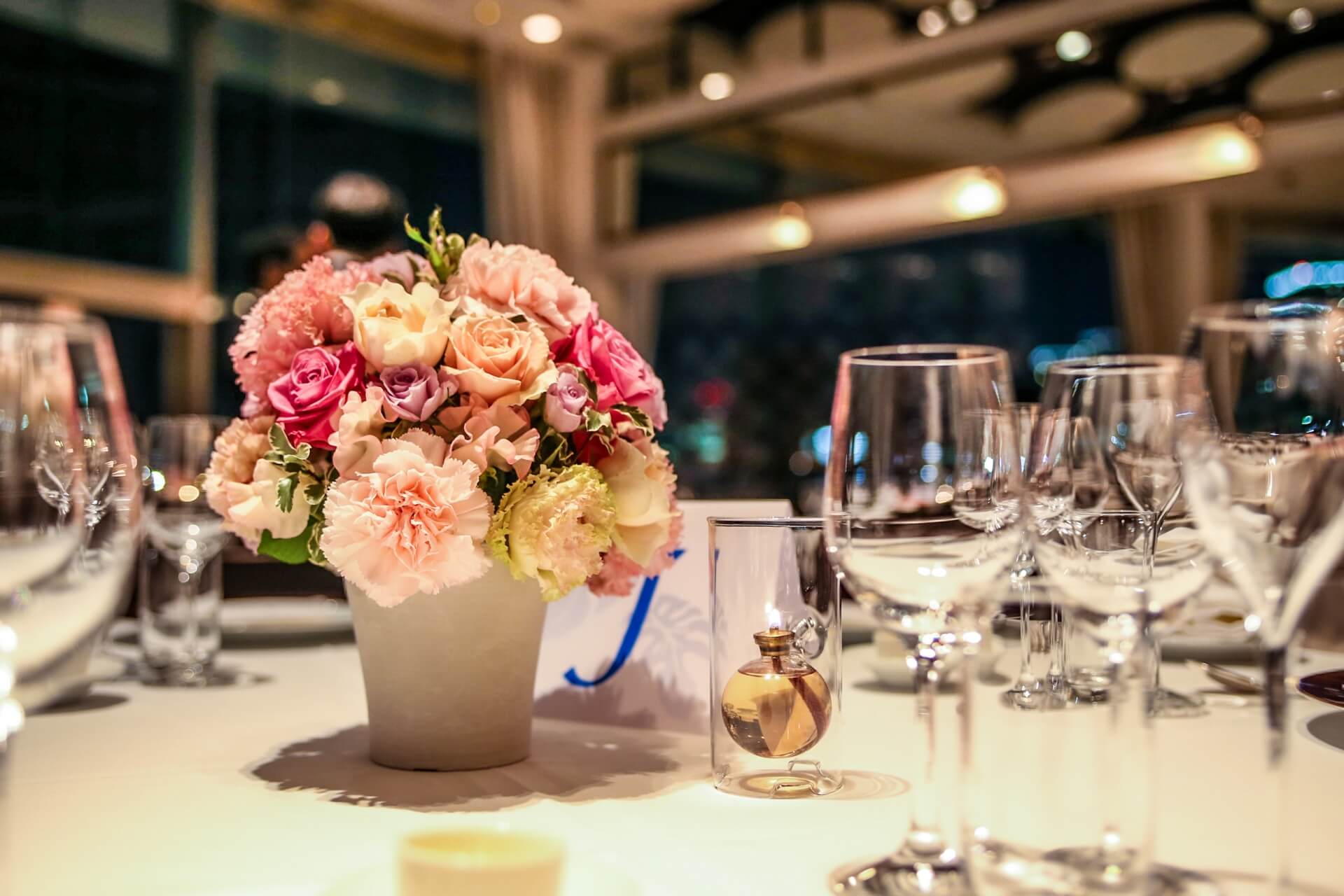 パーティー会場のテーブルに置かれたグラスや花